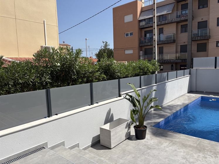 Glass fence with anthracite aluminium posts by the pool