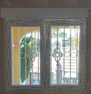 Two-leaf PVC window with a roller shutter